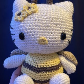 A crocheted Hello Kitty inspired plush wearing a bee costume.