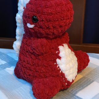 A crocheted red and white dinosaur.