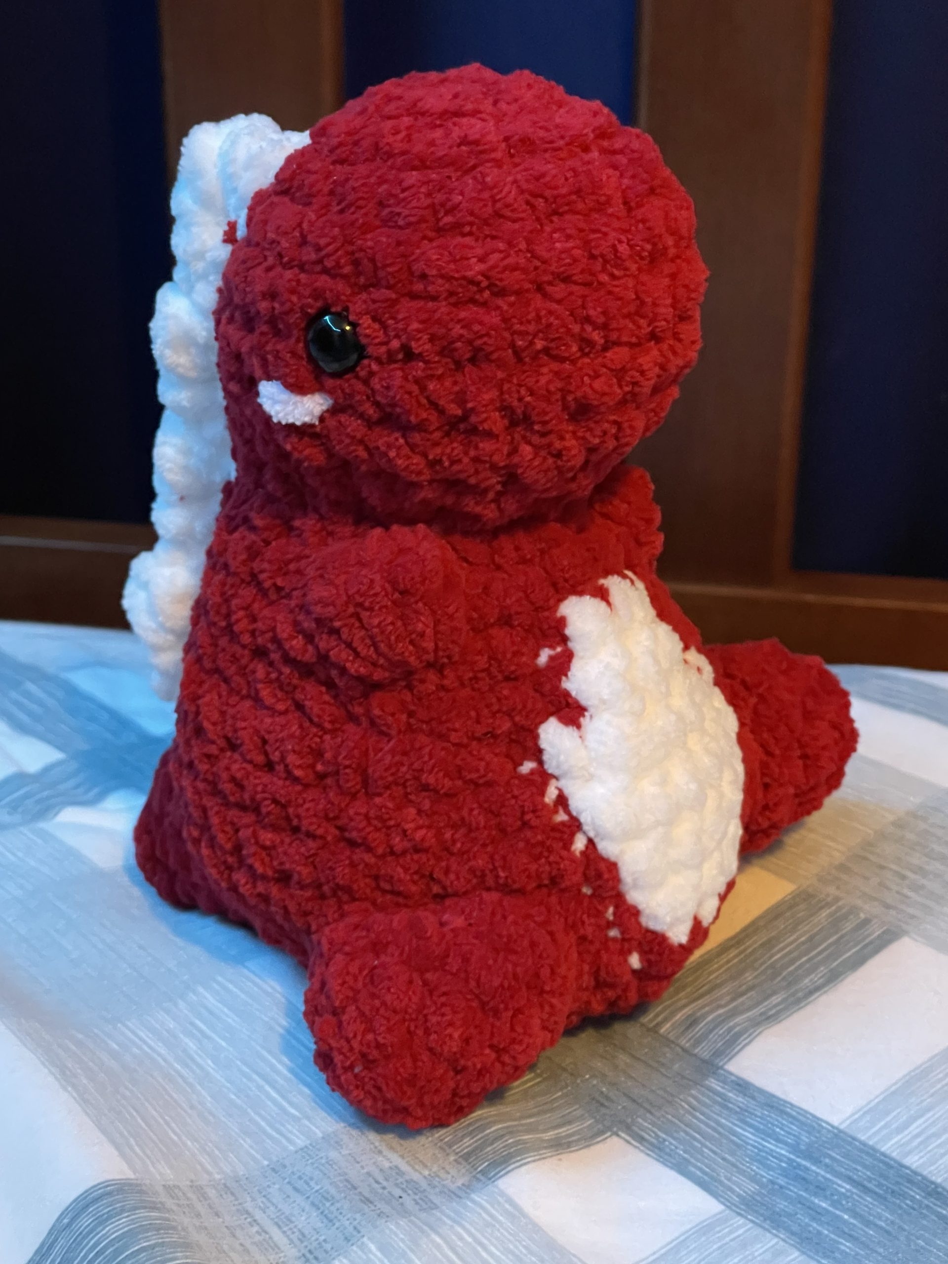 A crocheted red and white dinosaur.